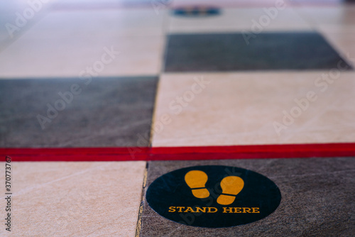 Stand here foot sign or symbol on the floor