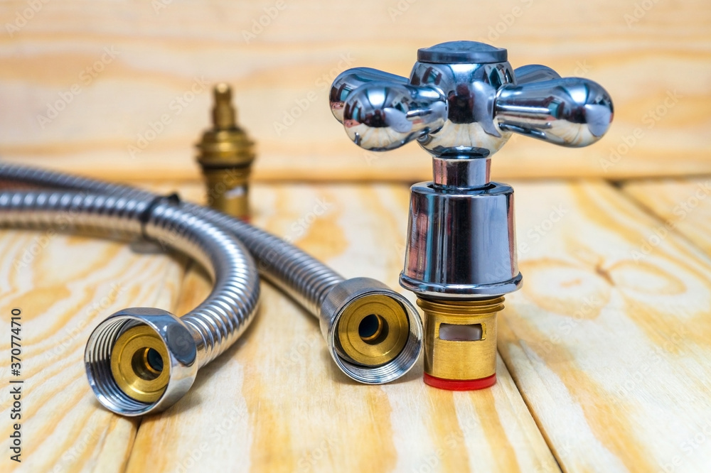 Cruciform hot and cold water main switch of spare parts on wooden boards Cruciform hot and cold water main switch of spare parts on wooden boards
