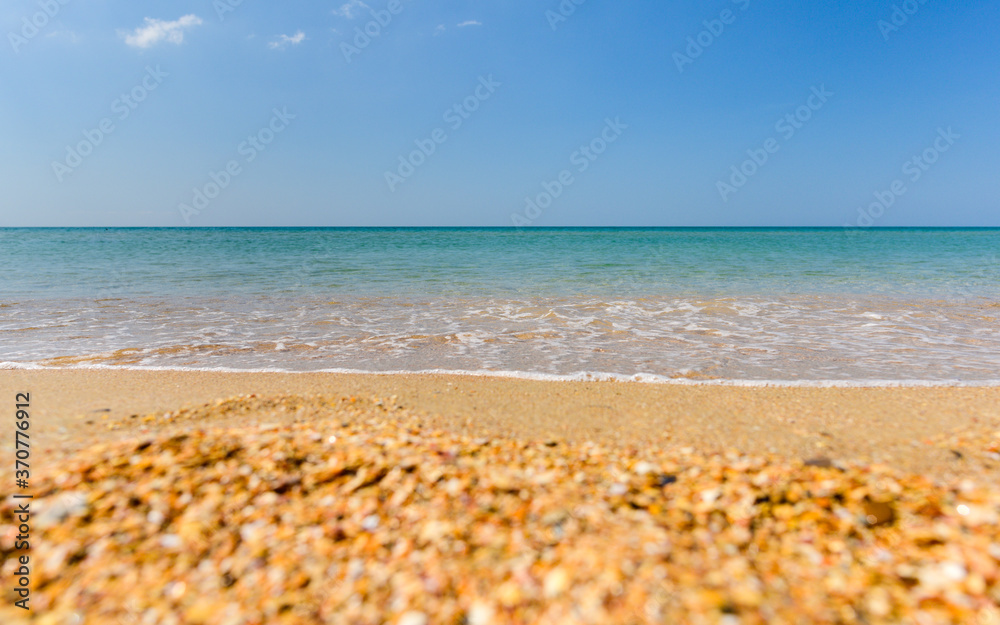 Blue sea and shell beach. Focus on the sea, the beach is blurred. Beautiful sea.