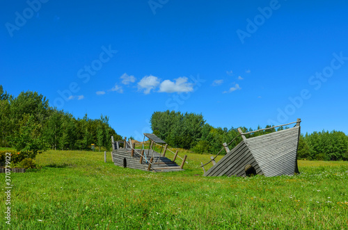 decorative wooden ship on a green field and blue sky