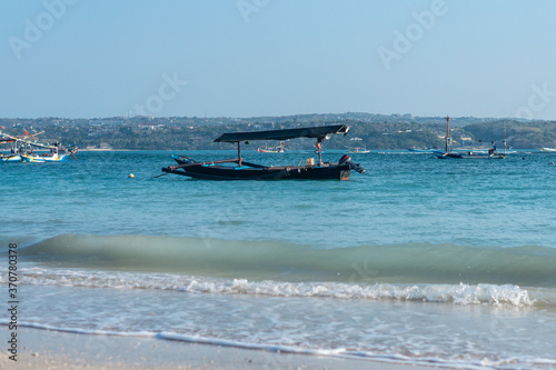 Fisherman black boat in the blue ocean