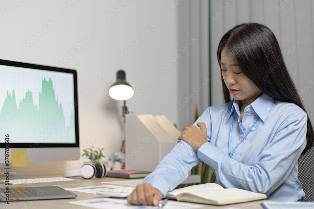Asian female employee is resting after her hard work and overtime late at the office, relaxing the body fatigue, Wrist pain. Asian female employee is resting after her hard work and overtime late at the office, relaxing the body fatigue, Wrist pain.