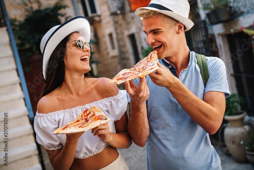 Couple eating pizza while traveling on vacation