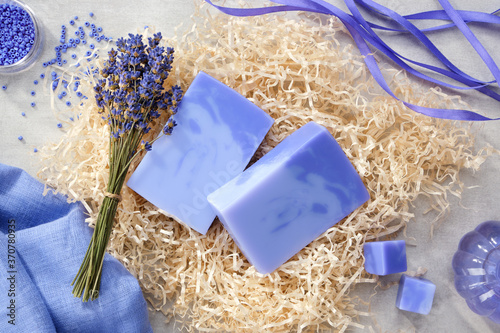 Two homemade lavender soap bars, lavender extract bottle and dry lavender flowers. Top view. photo