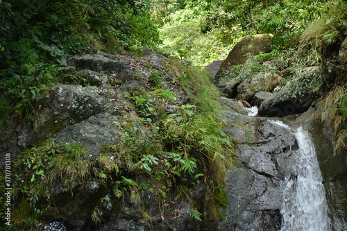 Tanawan water falls with big rocks and green leaves