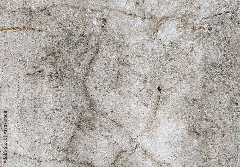 Wall background made of cracks. The texture of gray, dirty, cracked concrete.