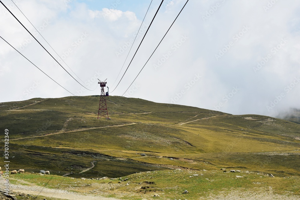 Obraz premium cable car on top of the mountain above the clouds