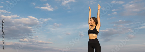 A young slim athletic girl in sportswear performs a set of exercises. Fitness and healthy lifestyle.