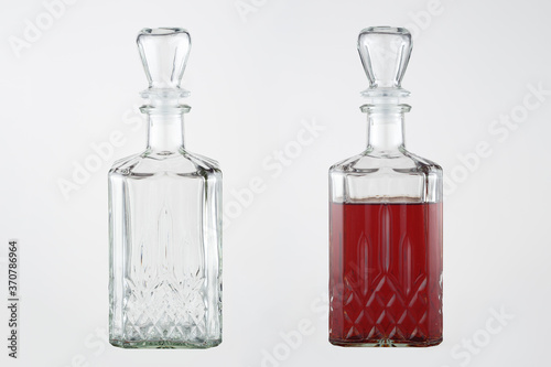 Homemade liqueur in a figured glass decanter with a glass stopper. A set of images on a gray background. Empty and full decanter.