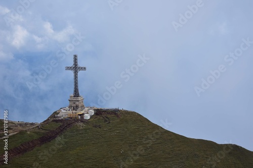 the cross of the heroes on top of the mountain above the clouds © badescu