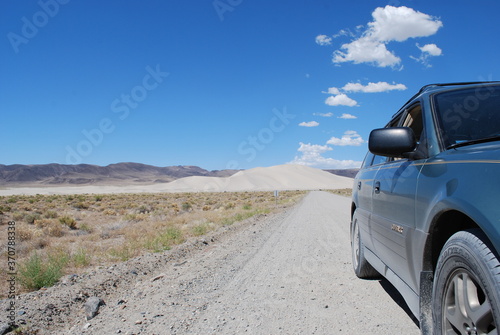 A car parked on a dirt road leading to Sand Mountain, a large singing sand dune east of Fallon, Nevada along  U.S. Route 50, AKA The Loneliest Road in America.  