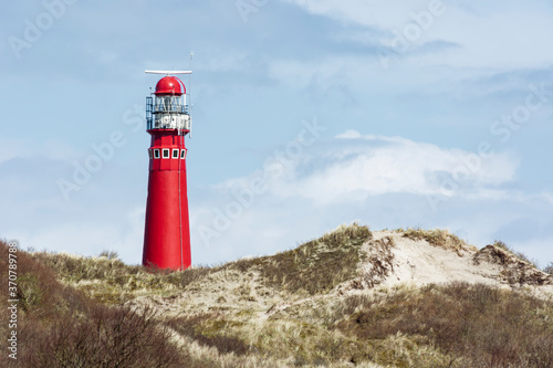 A red lighthouse behind dunes on Schiermonnikoog island, The Netherlands photo