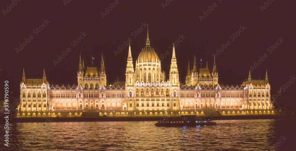 The Hungarian Parlament building at night in Budapestwith the Danube river