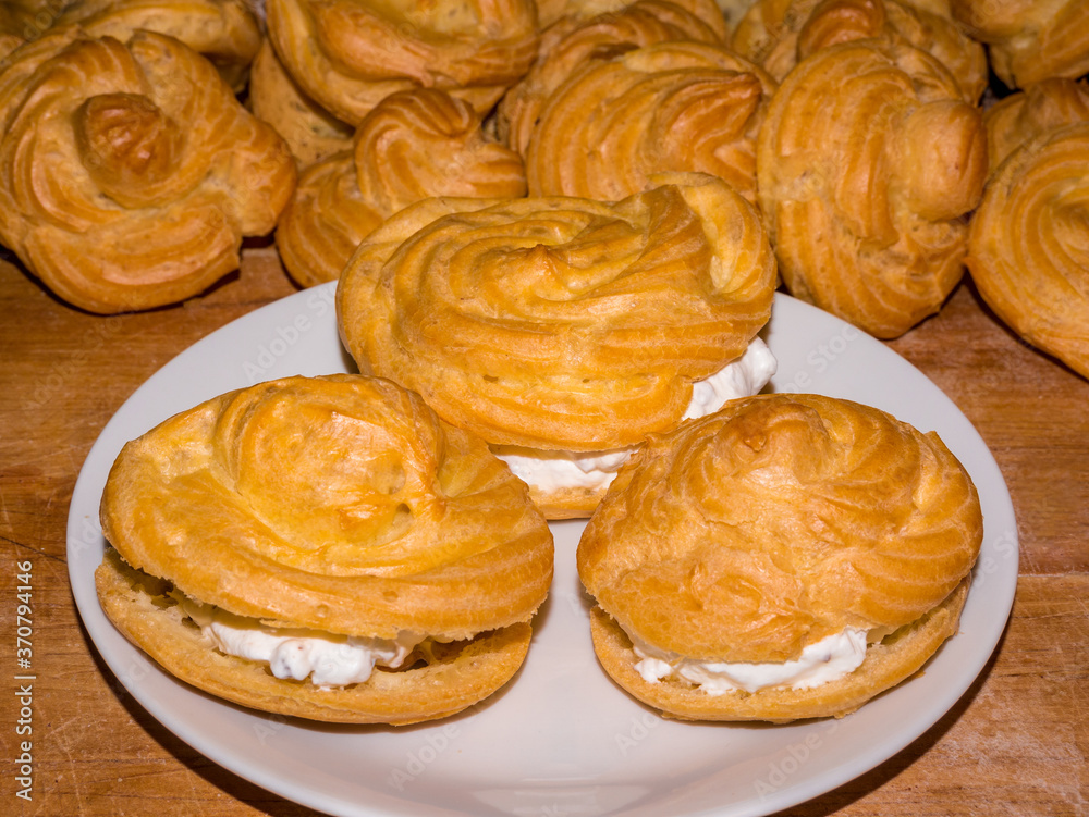 Profiterole or cream puff filled with whipped creamon a white plate