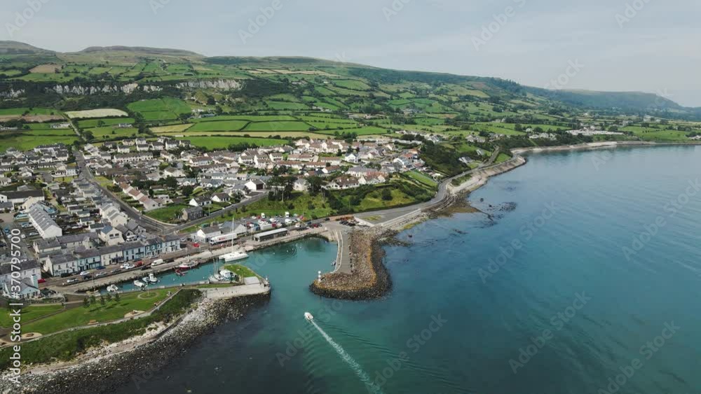 Static aerial shot of small boat sailing into harbor/marina - Northern Ireland Static aerial shot of small boat sailing into harbor/marina - Northern Ireland