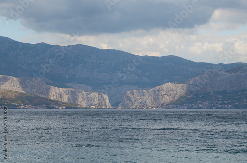 View of the town of Omis in Croatia, seen from the island of Brac from very far away. Two mountains meeting on the point where river flows into the adriatic sea