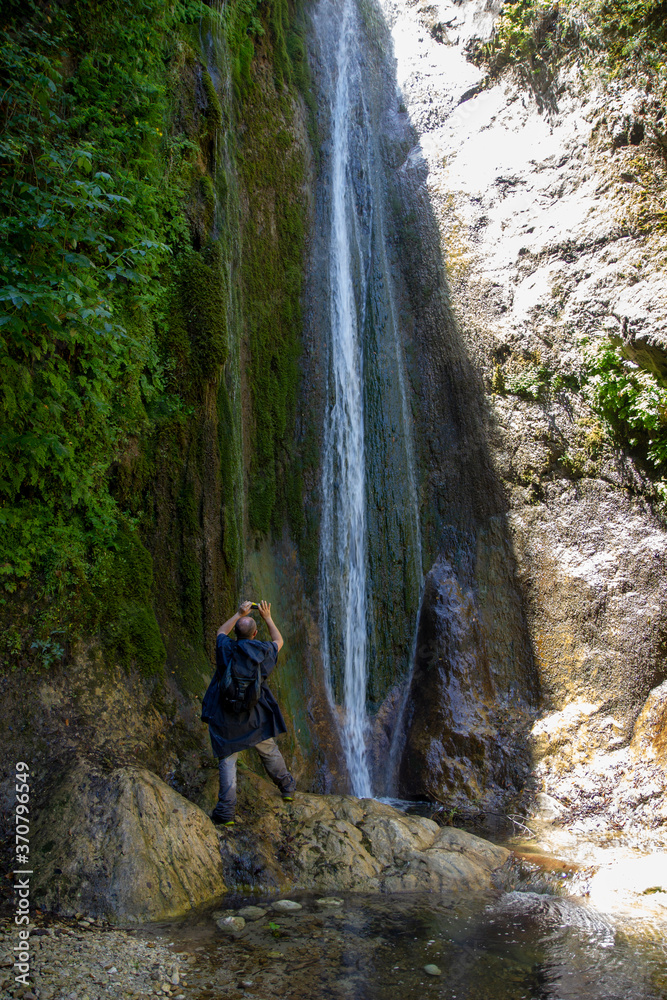 hiker photographing waterfall bard'natore in calabritto