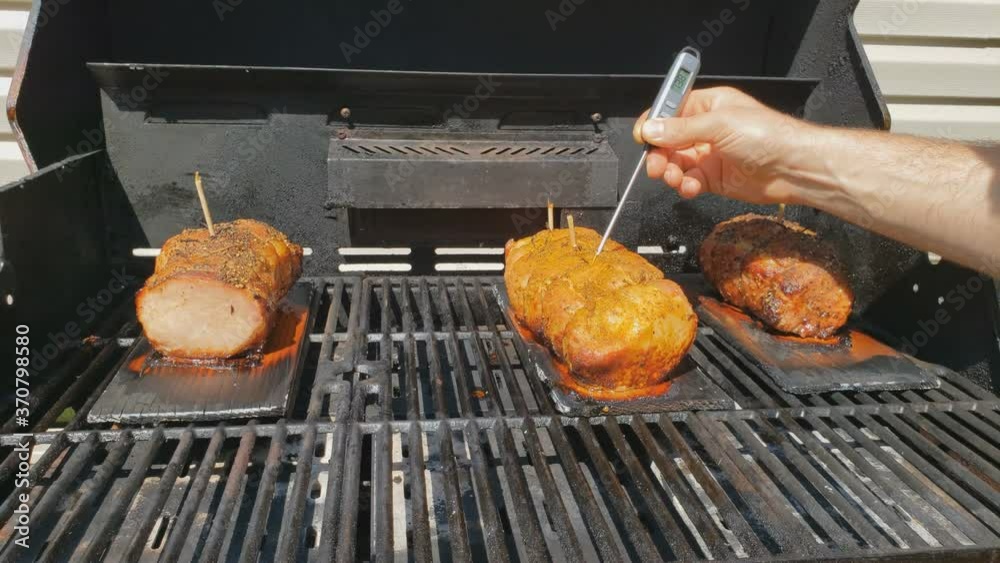 Home cooking Checking temperature of half loin pork ham being slowly