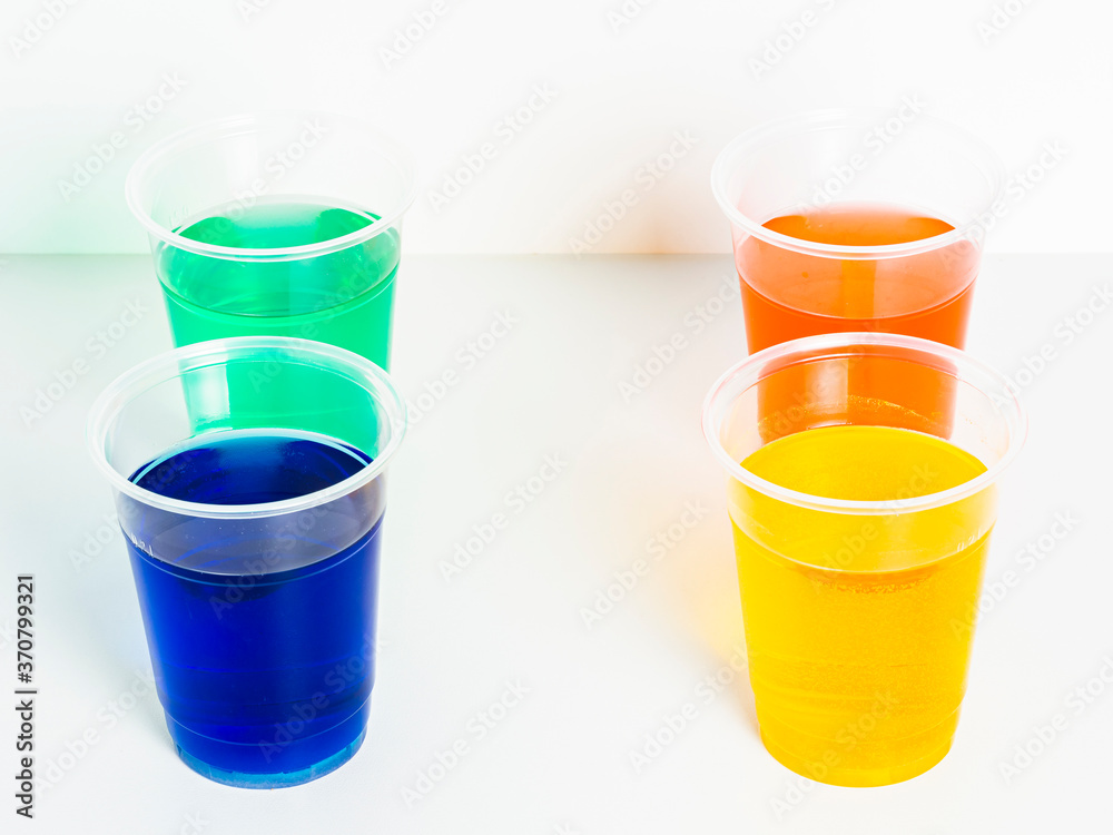 Four glasses with liquids of different colors on white background. Four glasses with liquids of different colors on white background.
