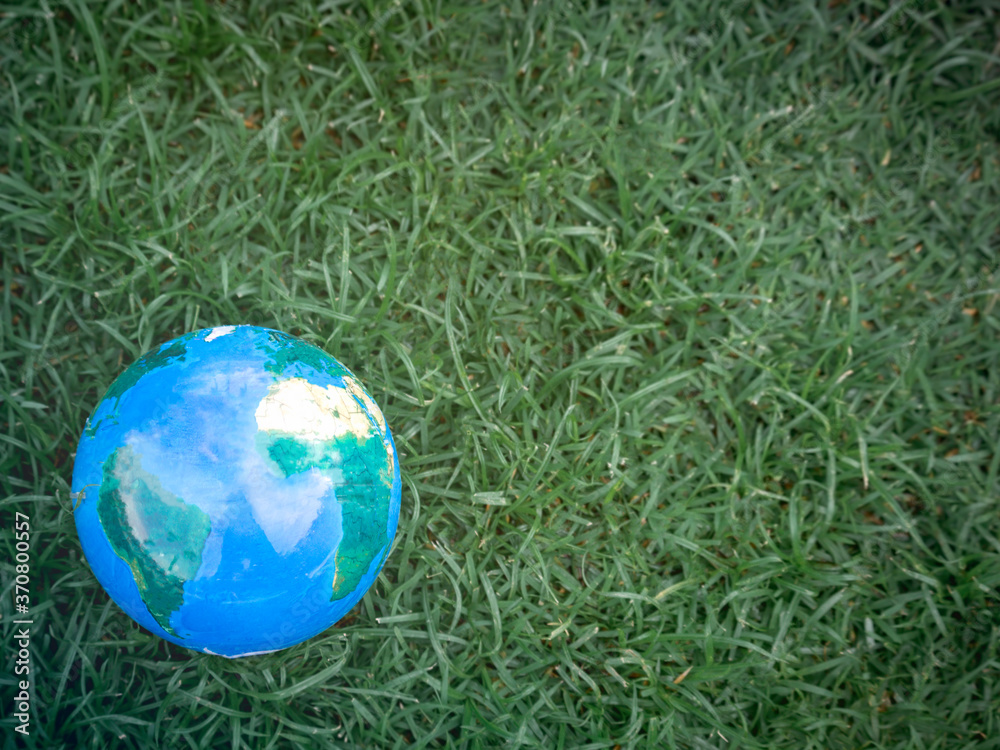 Earth on on green grass, save the world, love and protect our planet, and environmental friendly concept Earth on on green grass, save the world, love and protect our planet, and environmental friendly concept