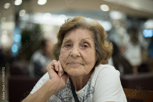 Mulher idosa sentada com olhar meigo. Sentimento de gratidão. 
