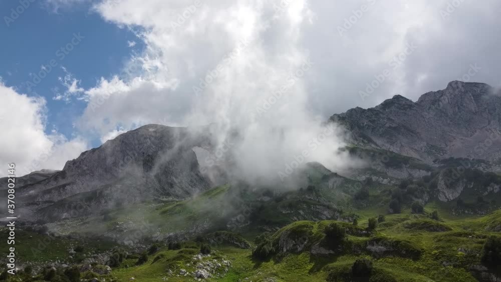 Flying over the mountains through the fog. The cloud is moving rapidly through the mountain valley. Timelapse. Aerial photography Flying over the mountains through the fog. The cloud is moving rapidly through the mountain valley. Timelapse. Aerial photography