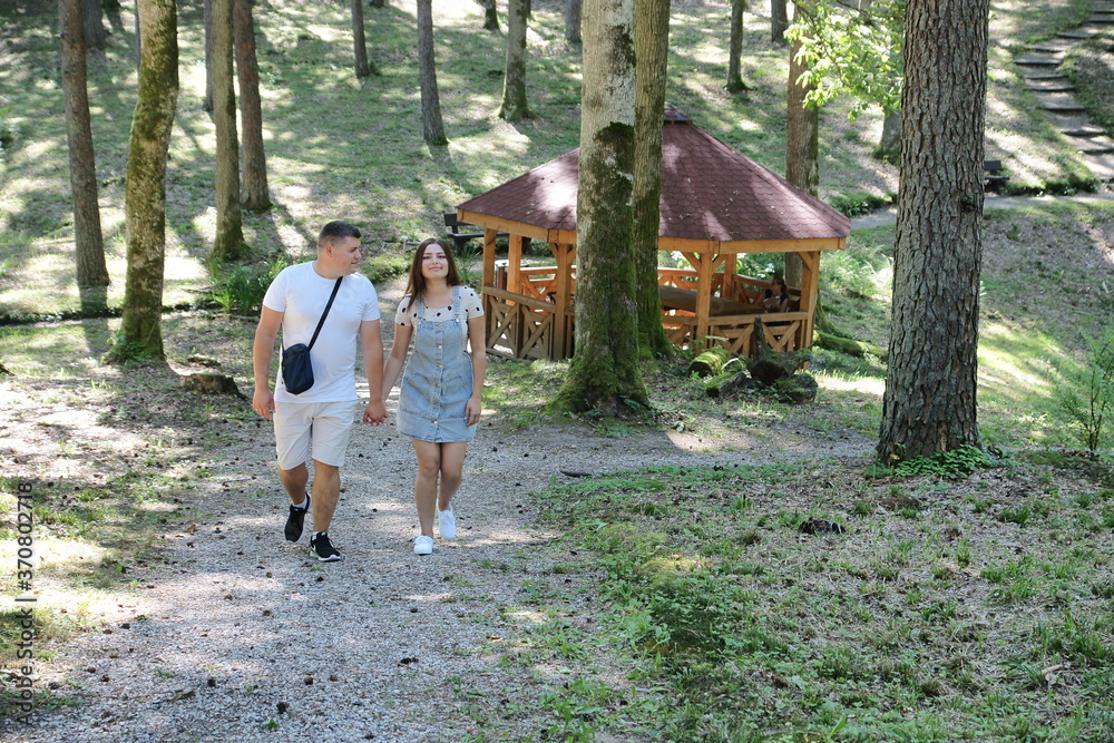 Fototapeta premium Boyfriend and girlfriend. Couple. In love. Forest Arboretum in Kudypy. Poland - Masuria - Warmia. Chłopak i dziewczyna. Para. Zakochani. Leśne Arboretum w Kudypach. Polska - Mazury - Warmia. 