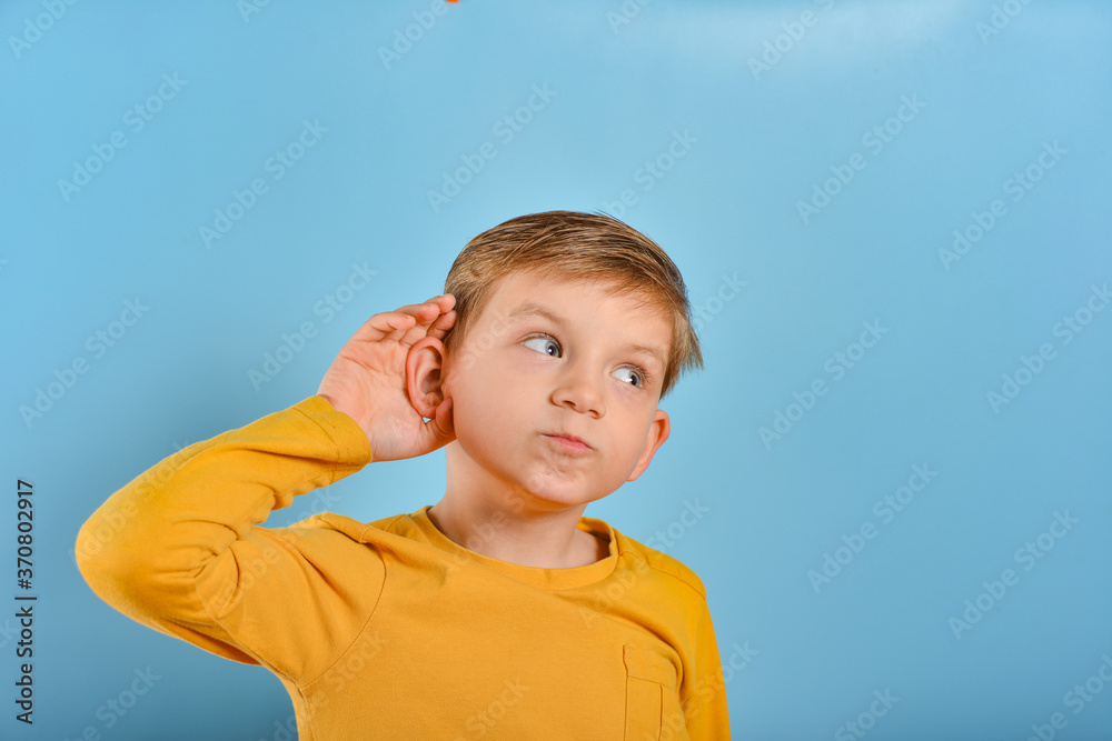 The boy scratches his ear and looks sideways. The boy scratches his ear and looks sideways.