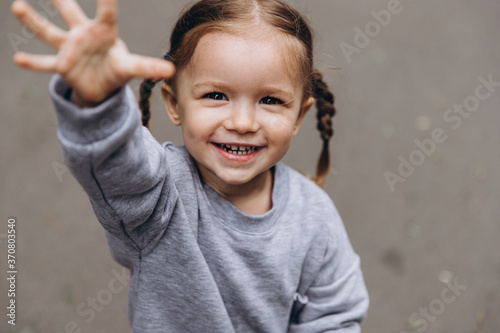 sincere children's laughter and fun, smiling girl playing and posing for a photo