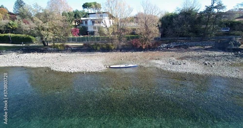 Shot of small boat filmed with a drone. The lake is called LagoMaggiore and its situated in northern italy. photo