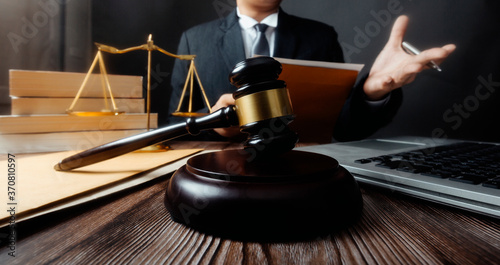 Business and lawyers discussing contract papers with brass scale on desk in office. Law, legal services, advice, justice and law concept picture with film grain effect