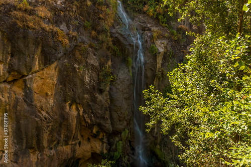 A waterfall cascades down the side of a mountain in the Sierra Nevada mountains outside Monachil, Spain in the summertime