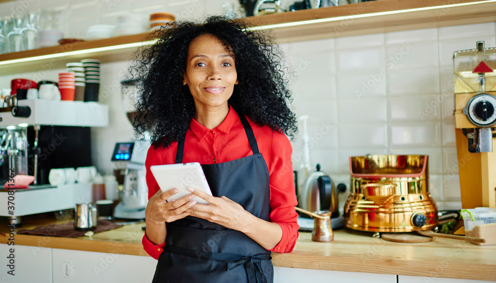 Black woman standing behind bar with tablet ready to take order Black woman standing behind bar with tablet ready to take order