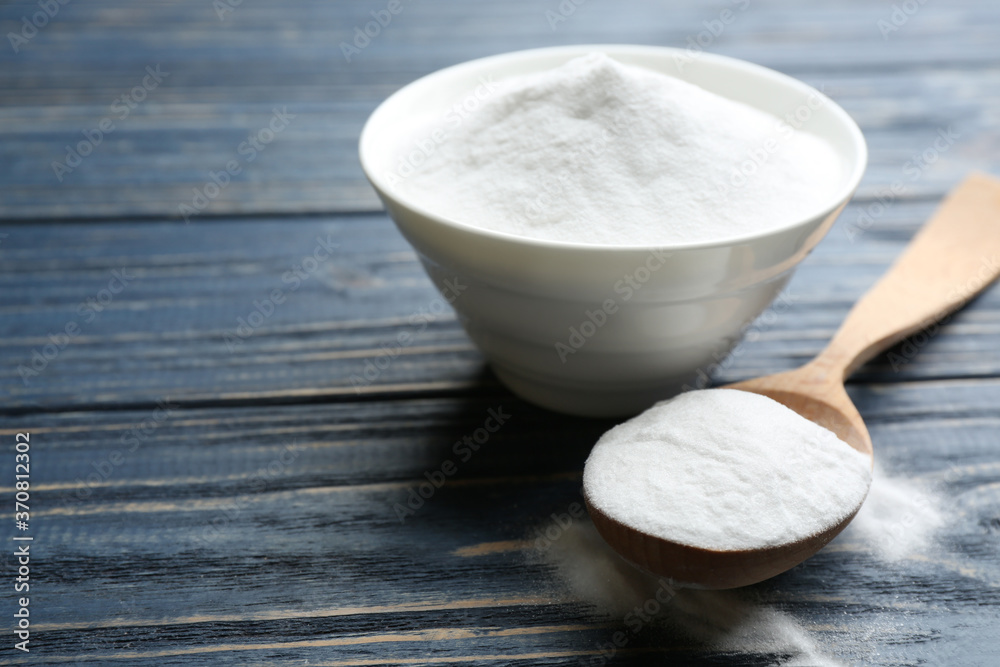 Baking soda in bowl on blue wooden table Baking soda in bowl on blue wooden table