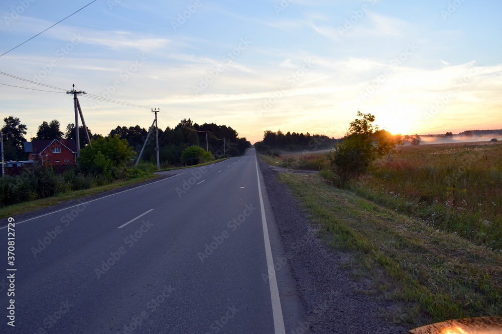 Fototapeta premium dawn on the road, the first rays of the sun