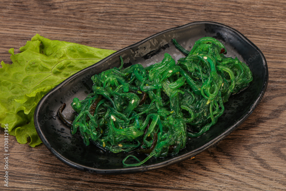 Green Chuka Seaweed Salad Isolated on White Background Top View. Wakame Sea Kelp Salat Green Chuka Seaweed Salad Isolated on White Background Top View. Wakame Sea Kelp Salat