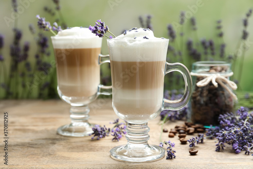 Delicious latte with lavender and coffee beans on wooden table