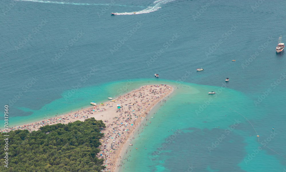 Zoomed in view from Vidova gora mountain of the famous golden Zlatni rat beach on the island of Brac. Famous for its shape, filled with tourists during the covid global pandemic in 2020
