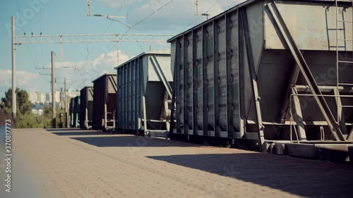 Electric Locomotive With Wagons Rides On Steel Railway.Heavy Industry Transportation Concept.Cargo Train Moving On Platform Staion.Kiev City Logictics.Freight Train Passing Through Passenger Station. photo