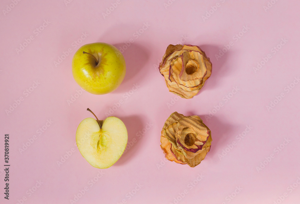 Natural apple chips on a pink background. Healthy vegan vegetarian fruit snacks. Organic products for wellness. Time to lose weight Natural apple chips on a pink background. Healthy vegan vegetarian fruit snacks. Organic products for wellness. Time to lose weight