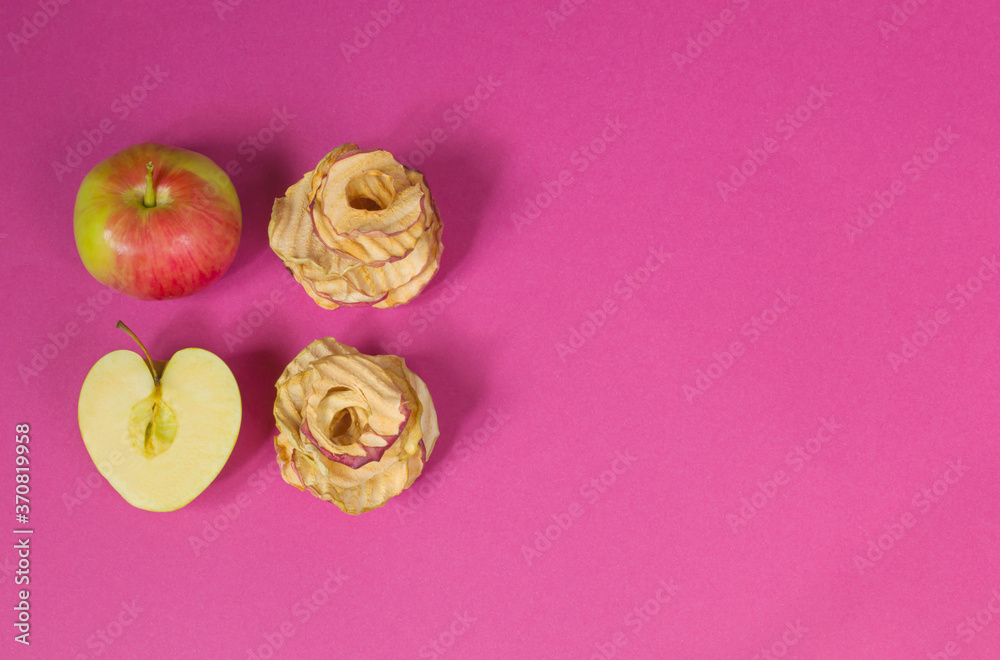 Natural apple chips on a pink background. Healthy vegan vegetarian fruit snacks. Organic products for wellness. Time to lose weight