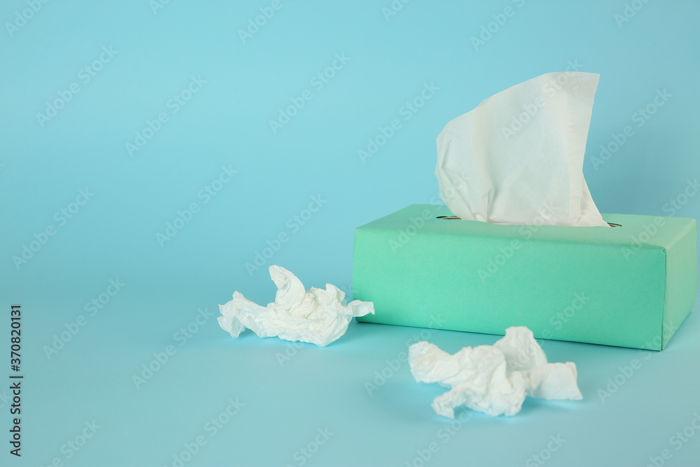 Used paper tissues and box on light blue background. Space for text Used paper tissues and box on light blue background. Space for text