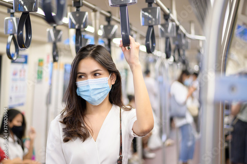 An young woman is wearing protective mask in metro , covid-19 protection , safety travel , new normal , social distancing , safety transportation , travel under pandemic concept