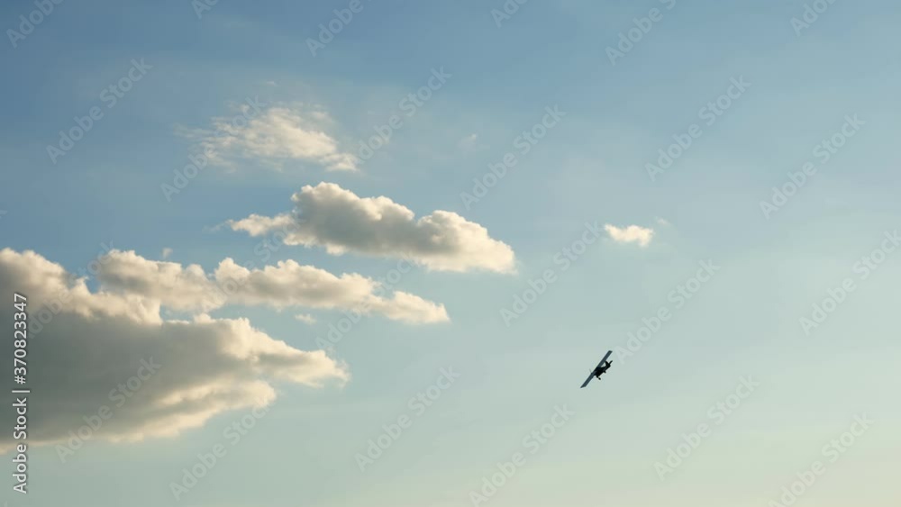 Retro airplane flying against a blue sky with dark storm clouds. sun rays are breaking through the clouds Retro airplane flying against a blue sky with dark storm clouds. sun rays are breaking through the clouds