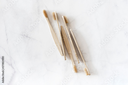 Composition with biodegradable bamboo toothbrushes on marble background. Sustainable, zero waste, plastic free, lifestyle concept. Eco-friendly oral hygiene accessories.Flat lay, top view, copy space.