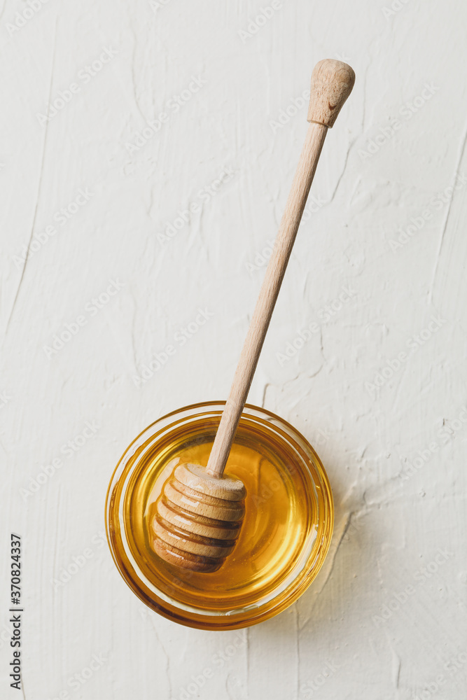 Bowl with honey and dipper on white background, top view Bowl with honey and dipper on white background, top view
