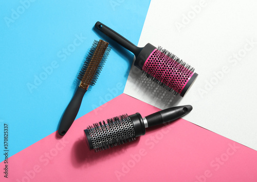 Fototapeta Naklejka Na Ścianę i Meble -  Round hair brushes on color background, flat lay