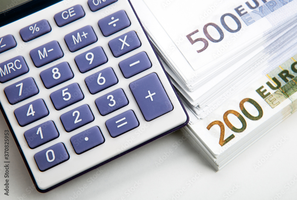 calculator and a bundle of banknotes 500 and 200 euros close up calculator and a bundle of banknotes 500 and 200 euros close up