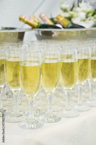 Catering on the event: sparkling wine on bottles and with glasses on the table with white cloth
