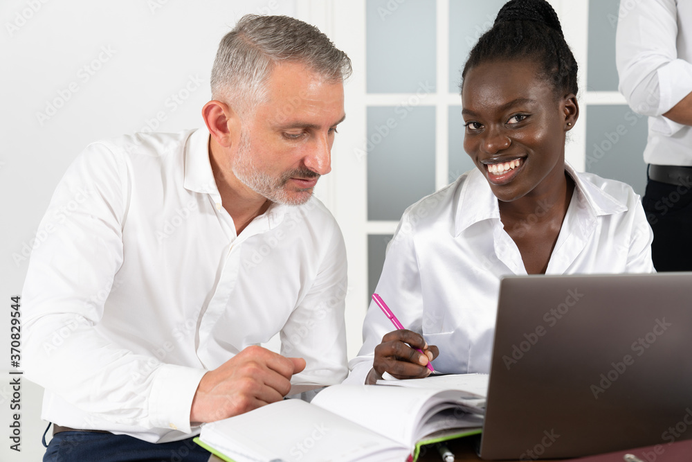 Fototapeta premium African American businesswoman consulting client about loan or insurance in boardroom, diverse colleagues working on online project together, discussing strategy